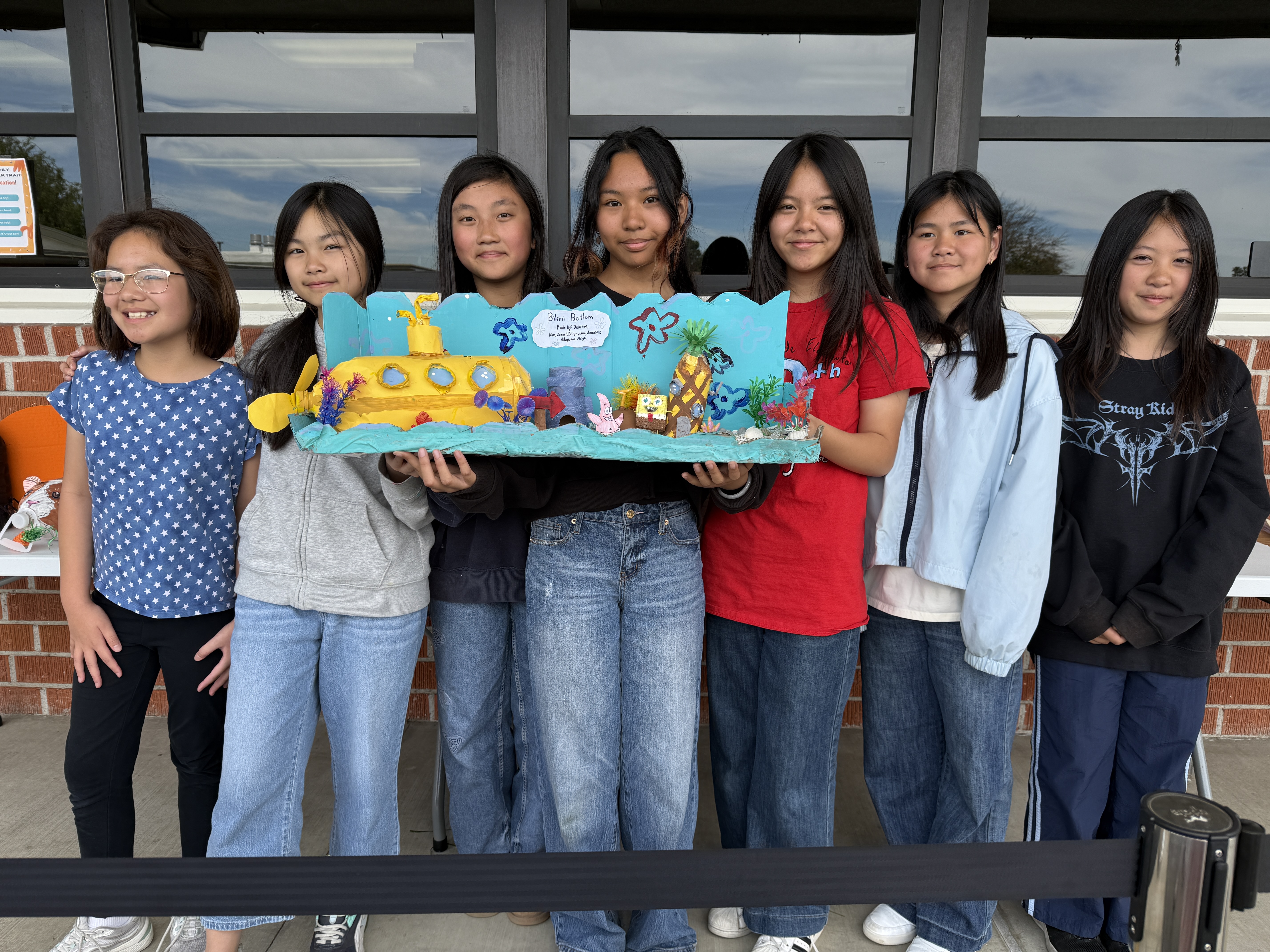 Room 52 scholars proudly pose with their winning coin jar